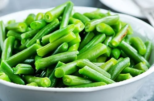 Porotos verdes (ejotes) crudos y cortados, listos para cocer para la tortilla.
