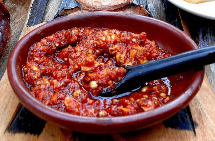 Salsa de merkén y ajo Salsa con ají color y merkén, lista para ser mezclada con el puré de papas.
