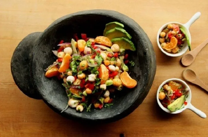 Ceviche de digüeñes Ceviche de digüeñes con palta, cebolla morada y cilantro, servido en una fuente de greda.
