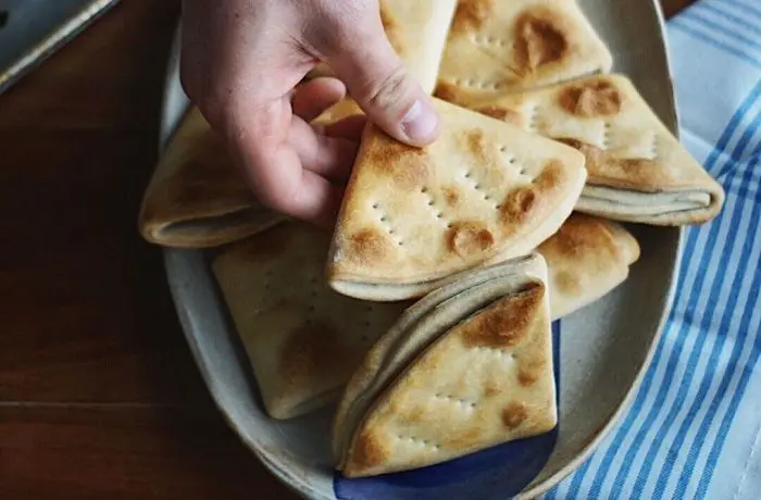 Dobladitas chilenas Dobladitas chilenas caseras horneadas, de color dorado y forma triangular.