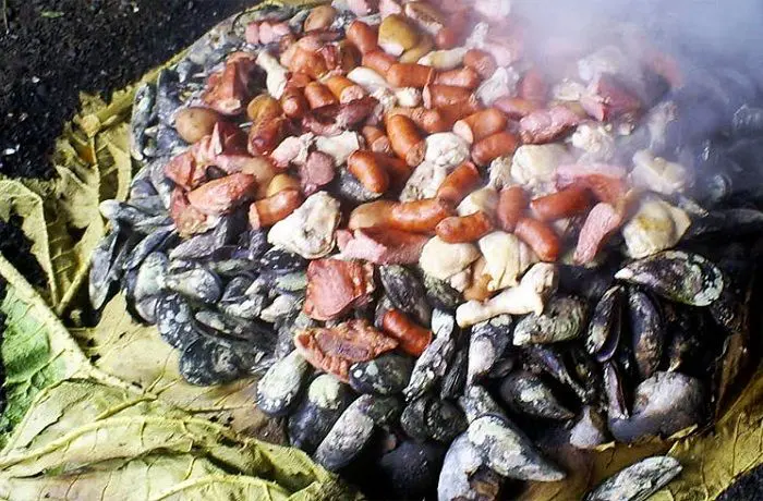 Curanto en hoyo chilote Curanto en hoyo. Preparación tradicional de Chiloé con mariscos, carnes y papas, cubierta con tierra para cocinarse al vapor.