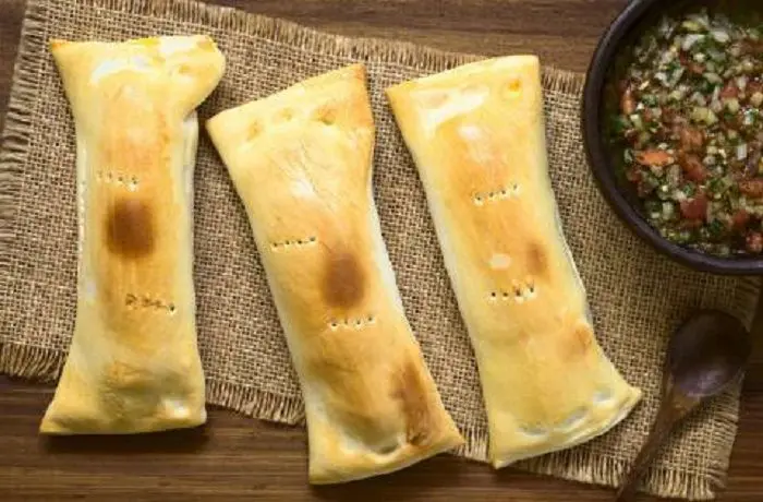 Chaparritas chilenas recién horneadas, servidas en un paño con pebre, listas para comer.