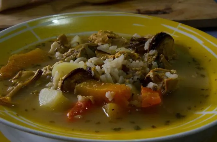 Cazuela chilota de cholgas secas con repollo Cazuela chilota con cholgas, repollo, papas y zapallo servida en un plato hondo con perejil.