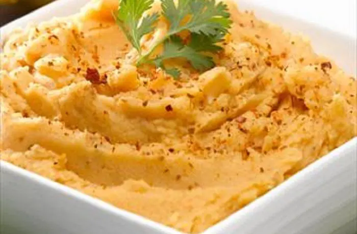 Puré de papas picante Puré de papas picante chileno cremoso, servido en un plato como acompañamiento.