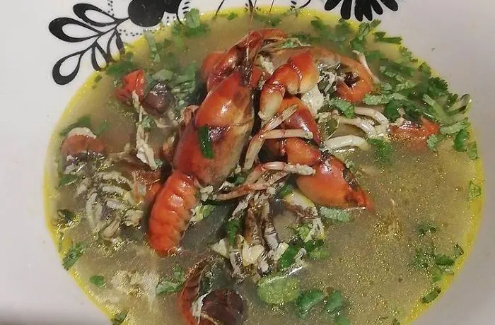 Caldillo de camarón de vega chileno servido en un plato hondo, con camarones y huevo en el caldo.