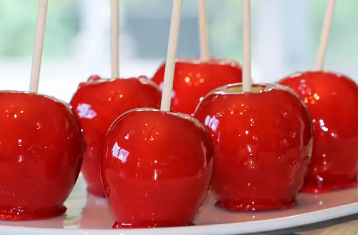 Manzanas confitadas caseras con caramelo rojo brillante, perfectas para fiestas infantiles.