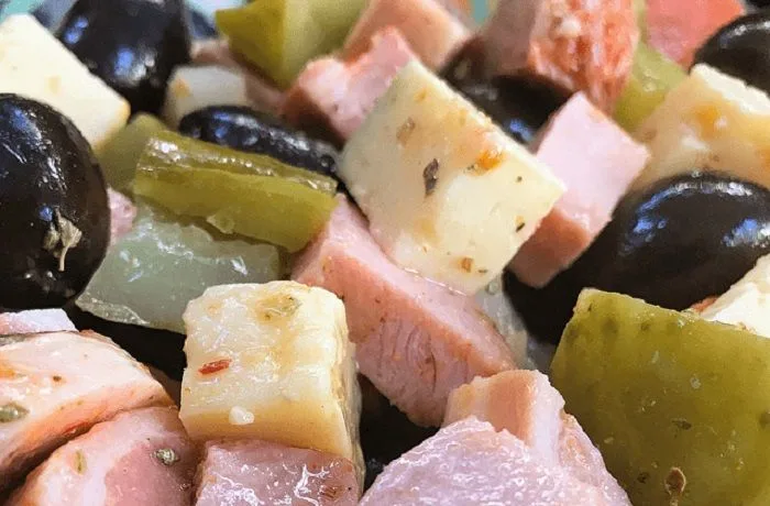 Pichanga fría chilena, mezcla de fiambres, queso, aceitunas y pickles, servida en una fuente para compartir.