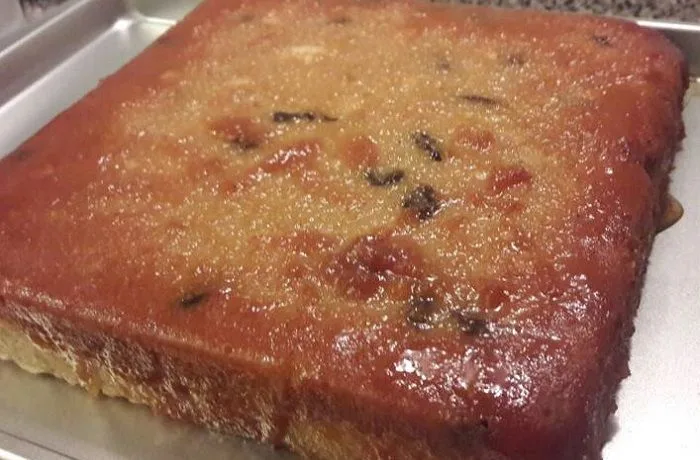 Colegial o budín de pan dulce chileno servido en rebanadas. Postre de aprovechamiento con caramelo y pasas.