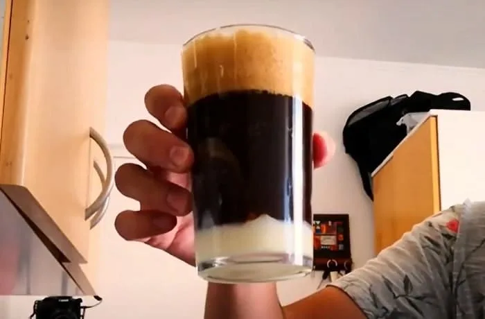 Cóctel de Malta con Cacao servido en vasos altos, con una capa de leche condensada en el fondo, hielo y cacao espolvoreado