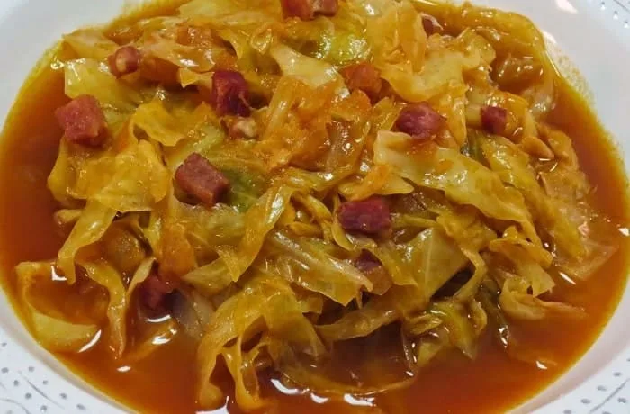 Guiso Don Fausto chileno servido caliente en un plato hondo: trozos de carne y repollo tierno cubiertos con un caldo espeso de comino y orégano.