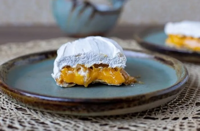 Príncipes chilenos montados con tres capas de hojarasca, rellenos de huevo mol amarillo intenso y cubiertos con un merengue suizo blanco y firme.
