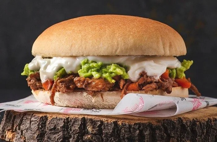 Sándwich de carne mechada italiana en marraqueta, con tomate, palta y mayonesa casera.