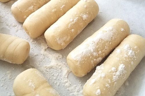 Tequeños crudos Tequeños crudos enrollados listos para freír sobre una bandeja