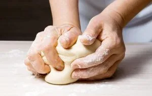 Amasado pan frica Masa de pan frica siendo amasada en una superficie enharinada.