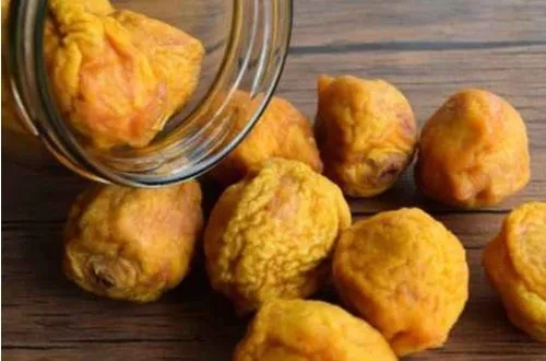 Huesillos secos Duraznos deshidratados (huesillos) en un bol, listos para el remojo y cocción en almíbar.