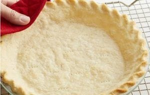 Masa de pie La masa extendida y pre-cocida en un molde, mostrando sus bordes definidos.