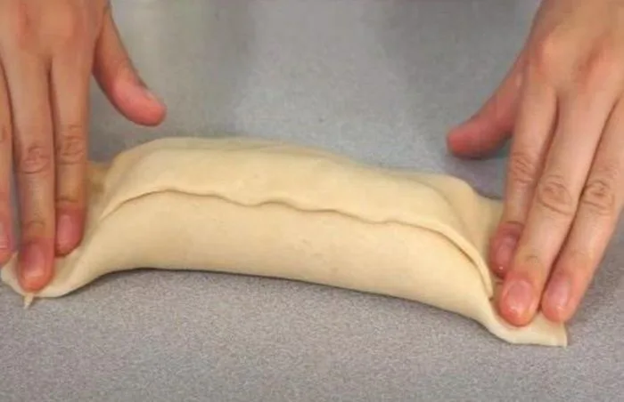 Trozos de masa estirada con el relleno de salchicha y queso, listos para ser sellados y formar las chaparritas