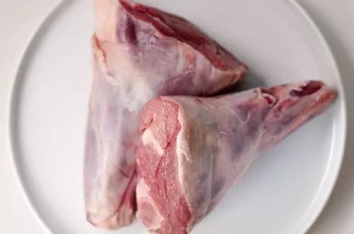 Garrones de cordero Garrones de cordero crudos, sazonados con merkén, pimienta y sal, listos para el marinado