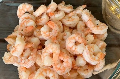 Camarones Camarones pelados y limpios de color grisáceo, preparados para dar el toque final de sabor a la paella.