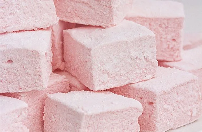 Receta de sustancias dulces y esponjosas: Marshmallows caseros chilenos 1 Plato con sustancias dulces caseras, de forma rectangular, espolvoreadas con maicena y azúcar flor, listas para servir