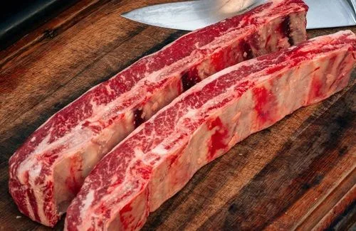 Asado de tira Corte de asado de tira de res con hueso, crudo y listo para sazonar.