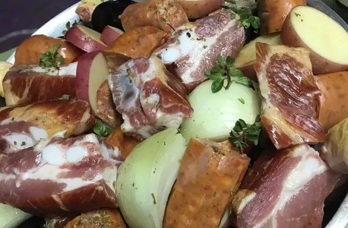 Cocimiento de mariscos y carne (mar y tierra) chileno, servido en olla con almejas, choritos, papas y costillar ahumado.