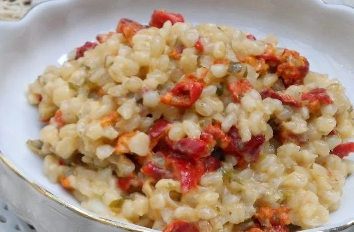 Risotto de piures chilenos cremoso, coronado con queso parmesano, perejil y semillas de cilantro.