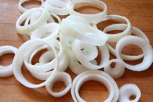 Aros cebolla Aros de cebolla pelados y cortados, con rebozado de harina y especias, antes de la fritura.