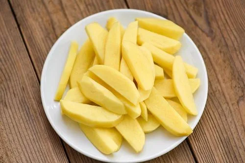 Papas en gajos Papas cortadas en gajos o medialunas, listas para ser añadidas a la sopa de choritos.