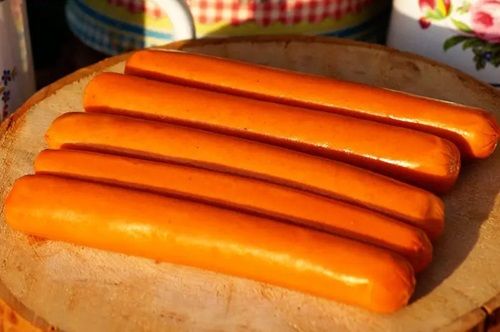Salchichas de cerdo en una tabla de cocina listas para ser cocidas en agua y preparar completos mojados.