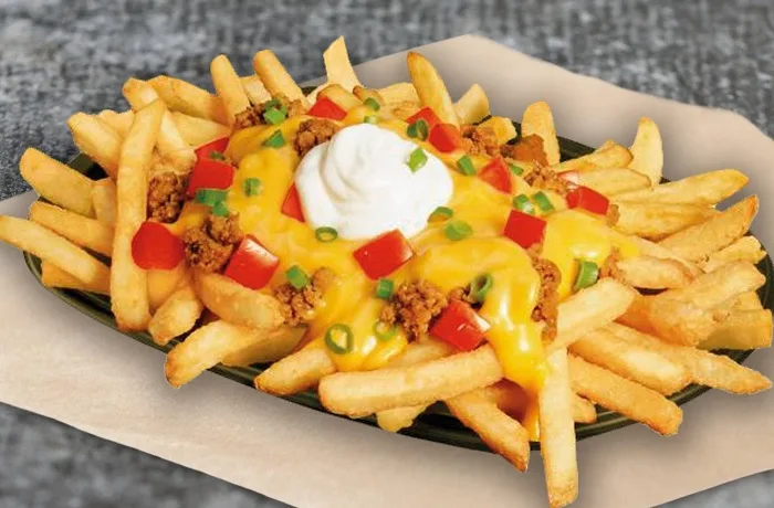 Receta de papas supremas: Clásico y versátil acompañamiento 1 Un plato abundante de papas fritas cubiertas con carne molida, salsa de queso cheddar derretida, cubos de tomate fresco, cebollín picado y un toque de yogurt natural.