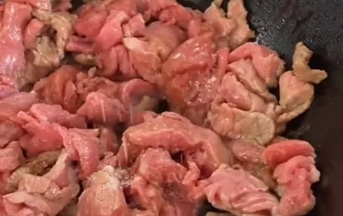 Cocinar la carne en un wok Técnica de salteado de carne a fuego alto en wok de acero, método chifa.