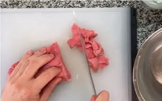Picar la carne Carne de res magra picada en trozos pequeños, lista para ser salteada.