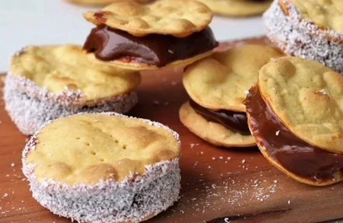 Alfajores chilenos de tres capas de hojarasca unidos con manjar y sellados con coco rallado en los bordes.