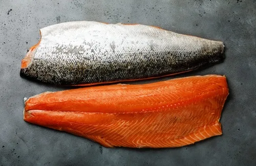 Filetes de salmón fresco con piel en proceso de marinado para cancato.