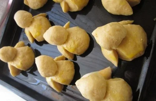 Pajaritos dulces crudos y con la forma ya dada, en una bandeja, listos para hornear.