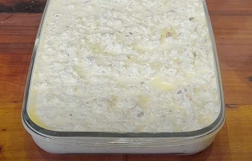 Budín antes de entrar al horno Budín de coliflor en la fuente de horno, cubierto con queso mozzarella laminado antes de hornear.