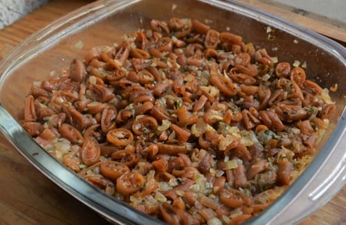 Relleno o pino de cochayuyo y cebolla, cocinándose en sartén con vino blanco.