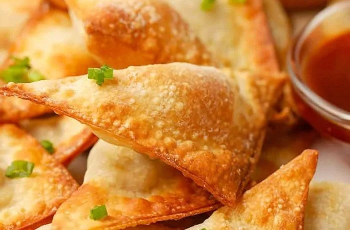 Wantanes fritos rellenos de cerdo y camarón, servidos crujientes con salsa agridulce china