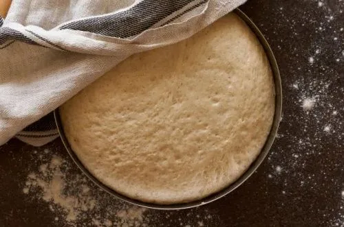 Masa leudante rollos Una masa de pan dulce suave y elástica descansando en un bol, habiendo duplicado su tamaño original tras el reposo.