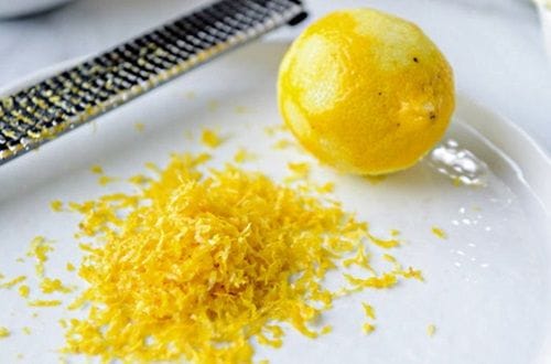 Ralladura de limón Ralladura de la cáscara de un limón fresco sobre un plato para capturar toda su esencia
