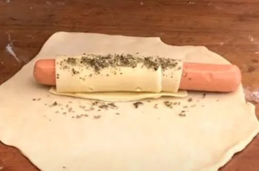 Salchichas de vienesa envueltas en láminas de queso, listas para envolver en la masa