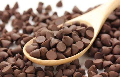 Chispas de chocolate Una pila de pequeñas gotas de chocolate oscuro, el complemento perfecto para añadir textura y sabor a las galletas saludables.
