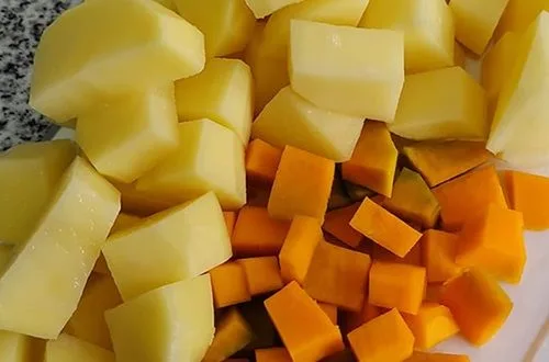 Papas y zapallo Trozos grandes de papas y zapallo (calabaza) en el caldo, cocinándose para la cazuela.