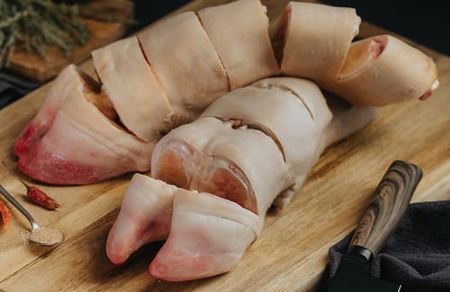 Trozos de patas de vacuno o res crudas, listas para la cocción a presión.