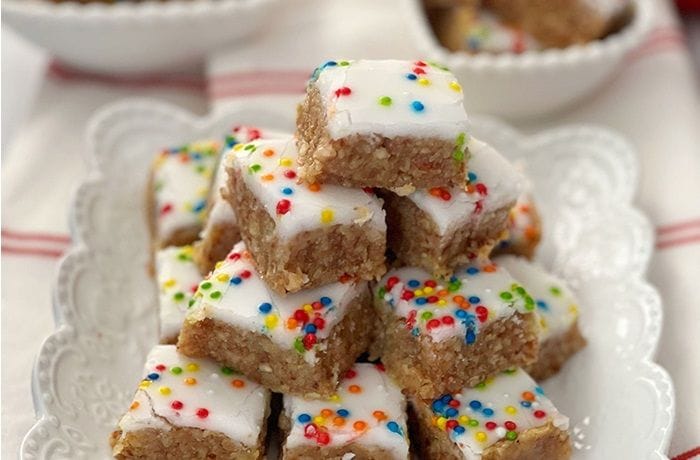 Receta de dulces San Estanislao: Tradicionales en cumpleaños y Navidad 1 Bandeja de Dulces San Estanislao chilenos, cuadritos de manjar con almendras cubiertos de glasé blanco y mostacillas de colores.