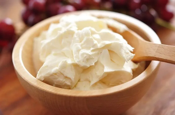 Batiendo queso mascarpone en un bol para la crema de tiramisú