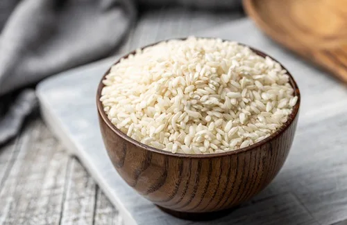 Arroz arbóreo (Arborio) de grano corto y alto en almidón, ideal para la cremosidad del risotto.