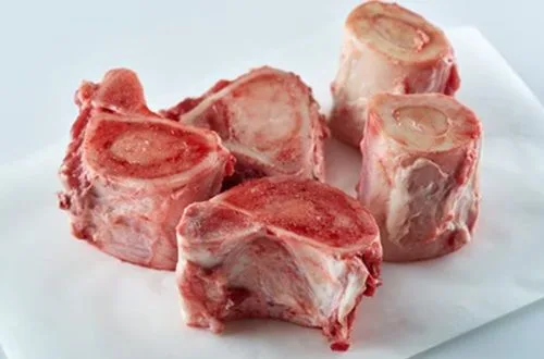 Huesos para caldo Huesos de res tostados y dorados en una bandeja de horno, listos para ser procesados.