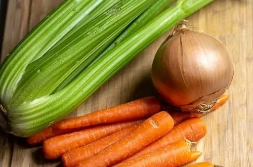 Ajo, zanahoria y apio Ajo, zanahoria en rodajas y apio picado, las verduras para el sofrito del tapapecho a la olla.
